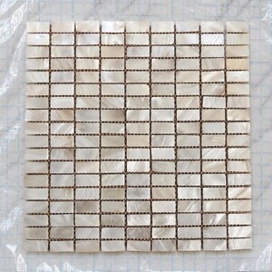 Peut inclure: Une feuille de mosaïque carrée composée de petites pièces rectangulaires en nacre irisée disposées en grille. Les carreaux présentent une finition blanche nacrée naturelle avec de subtiles variations de tons, montés sur un support quadrillé transparent.