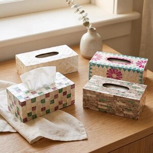 Puede incluir: Cuatro cajas rectangulares para pañuelos hechas de azulejos de concha iridiscente. Una es blanca, otra tiene patrones florales rosas y turquesas, otra un diseño de tablero de ajedrez verde y morado, y otra un patrón de ladrillos marrón y verde.