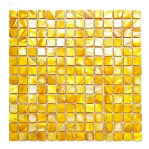 Può includere: Un foglio di piastrelle a mosaico quadrato composto da numerose piccole piastrelle quadrate. Le piastrelle hanno una finitura perlescente e iridescente con sfumature di giallo, oro e bianco. L'effetto complessivo è una superficie scintillante e strutturata.