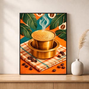 May include: A framed wall art print featuring a brass South Indian coffee filter set on a plaid cloth with scattered coffee beans. The background displays vibrant orange tones and large green tropical leaves, with steam rising from the hot coffee.