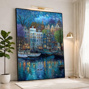 Könnte beinhalten: Ein großer, gerahmter Leinwandkunstdruck, der eine nächtliche Stadtlandschaft mit Gebäuden, Booten und Wasser zeigt. Das Kunstwerk weist eine lebendige Farbpalette aus Blau-, Grün- und Lilatönen auf, mit Reflexionen im Wasser. Der Himmel ist tiefblau mit einem Halbmond und Sternen.