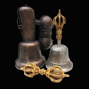 May include: An assortment of ornate bells and ritual objects. The image features a large copper-colored bell with intricate floral patterns, a silver bell with a gold crown handle, and a gold vajra scepter. The objects are set against a black background.