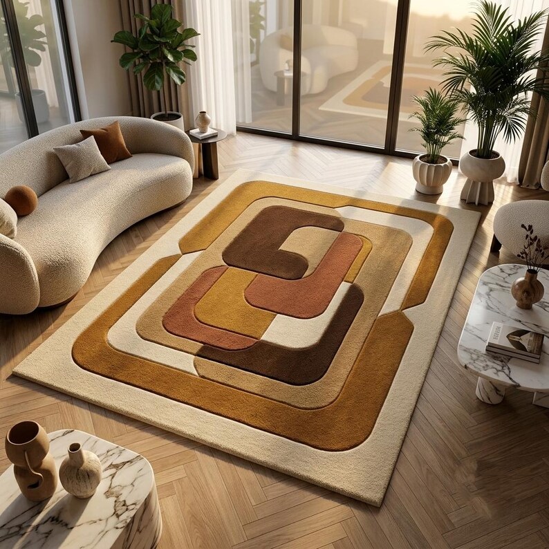 May include: A rectangular area rug featuring a layered geometric pattern with rounded corners. The design consists of concentric shapes in shades of cream, mustard yellow, terracotta orange, and dark brown, creating a textured, dimensional effect.