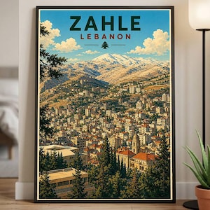 May include: A framed vintage travel poster for Zahle, Lebanon, depicting the city in a valley with snow-covered mountains. The poster has a blue sky with clouds and the text "ZAHLE LEBANON". The artwork is framed in a black border.
