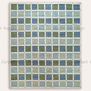 May include: A rectangular rug with a checkered pattern of blue and green squares on a cream background. The rug has a textured appearance and is likely made of woven material. The words "Carpet Knot Rugs" are printed on the top and bottom of the image.
