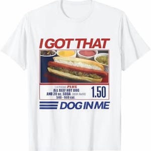 May include: A white short-sleeve t-shirt featuring a graphic of a hot dog with the text I GOT THAT DOG IN ME. The design includes a menu-style layout with the text 1/4 POUND PLUS ALL BEEF HOT DOG AND 20 oz. SODA (With Refill) 540-960 cal. 1.50.