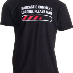 Op de afbeelding: Een zwart t-shirt met korte mouwen en witte tekst "SARCASTIC COMMENT LOADING, PLEASE WAIT" boven een wit omrande laadbalk-afbeelding, waarbij rode diagonale strepen de voortgangsbalk op de borst gedeeltelijk opvullen.