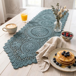 May include: A white ceramic mug with a black handle and the text "But First, Coffee" in a black, bold font. The mug is on a white surface. The mug is approximately 10 cm tall.