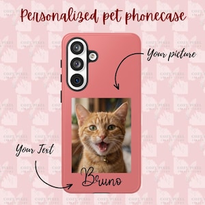 May include: A coral-colored phone case featuring a rectangular photo of an orange tabby cat with an open mouth. The case includes the text "Your picture" with an arrow pointing to the photo area, and the name "Bruno" printed below the image.