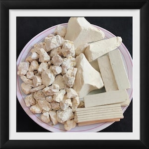 May include: A plate of various shapes of white clay, including chunks, blocks, and sticks. The clay is a light beige color and appears to be natural. The plate has a pink and white rim.