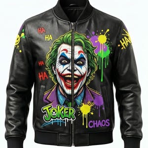 May include: Black leather bomber jacket featuring a vibrant graphic of the Joker with green hair, white face paint, and red lips. The jacket has the word "Joker" and "Chaos" in graffiti style, with "Ha Ha" text and colorful paint splatters.