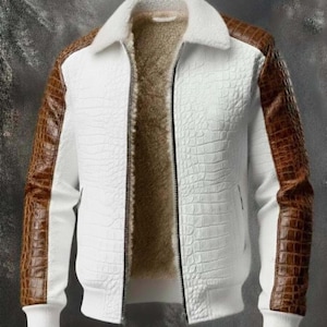 Puede incluir: Una chaqueta blanca con un patrón texturizado de piel de cocodrilo en los paneles frontales y mangas de piel de cocodrilo marrón. La prenda incluye un cuello de piel sintética blanca, un forro interior de piel sintética beige.
