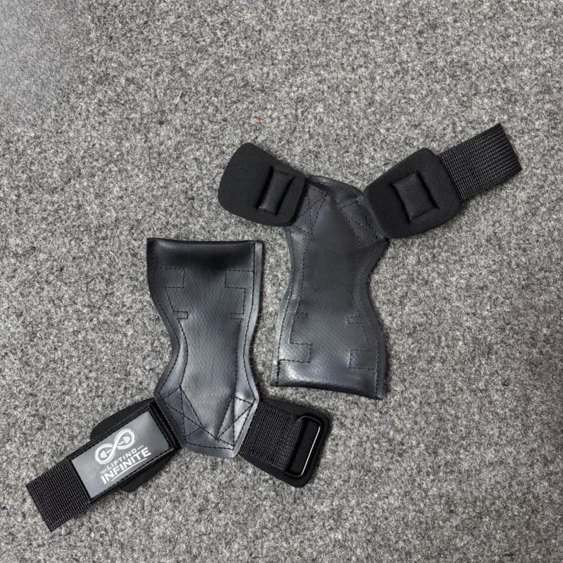 Puede incluir: Dos agarres de halterofilia negros con correas para la mu&ntilde;eca. Los agarres son de material similar al cuero y tienen un &aacute;rea acolchada para la palma. Las correas de mu&ntilde;eca tienen una hebilla met&aacute;lica y una etiqueta "Lifting Infinite".