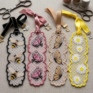 Puede incluir: Cuatro marcapáginas rectangulares con intrincado bordado de encaje. El primero es negro con tres abejas, el segundo rosa con tres mariposas, el tercero beige con tres mariposas y el cuarto amarillo con flores de margarita blancas.