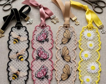 May include: Four rectangular bookmarks featuring intricate lace embroidery. The first is black with three bees, the second is pink with three butterflies, the third is beige with three butterflies, and the fourth is yellow with white daisy flowers.