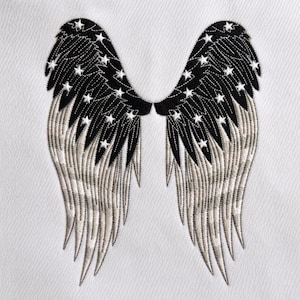 May include: An embroidered patch featuring a pair of symmetrical wings on a white fabric background. The upper sections of the wings are black with white star accents, while the lower portions feature detailed white and grey feather stitching.