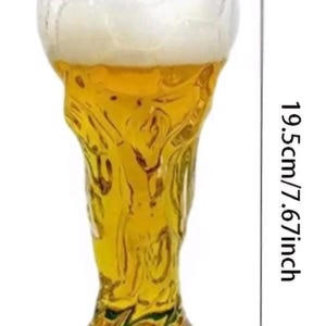 May include: A 500ml premium glass shaped like a trophy, filled with a golden liquid. The glass has a diameter of 3.346 inches at the top, a 2.755 inch base diameter, and a total height of 7.67 inches. The base features a dark green accent.