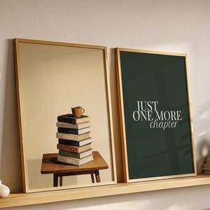 May include: Two framed rectangular wall art prints with light wood frames. The left print shows a stack of books on a small table with a cup on top. The right print has a dark green background with the white text JUST ONE MORE chapter.