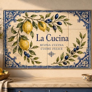 May include: A rectangular wall tile mural featuring a cream background with a blue decorative border. The design displays yellow lemons and dark blue olives on green branches. The text reads La Cucina, Buona Cucina, Cuore Felice.