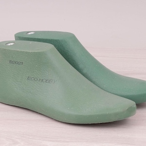 Puede incluir: Dos hormas de zapatos verdes, una delante de la otra, con el texto "B2021" y "ECO HOBBY" impreso en el lateral. Las hormas están hechas de un material sólido y están diseñadas para dar forma a los zapatos.