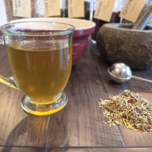 K&ouml;nnte beinhalten: Eine wei&szlig;e Keramik-Tasse mit schwarzem Henkel und dem Text "But First, Coffee" in fetter, schwarzer Schrift. Die Tasse steht vor einem neutralen Hintergrund, der ihr schlichtes Design hervorhebt.
