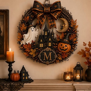 May include: A decorative Halloween wreath featuring a large black and orange patterned bow at the top, a central haunted house, a white ghost, a crescent moon face, and a jack-o'-lantern, all accented with autumn leaves and a letter M emblem.