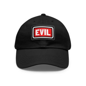 Pode incluir: Boné de beisebol preto com um patch retangular. O patch tem uma borda branca, um fundo vermelho e a palavra "EVIL" em letras brancas maiúsculas. O boné é feito de um material macio e tem uma aba curva.