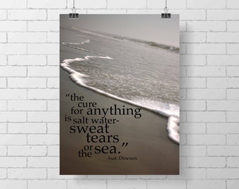 May include: A poster with a beach scene and the quote "the cure for anything is salt water-sweat tears or sea." The quote is attributed to Isak Dinesen. The poster is held by two black binder clips.