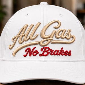 Könnte beinhalten: Eine weiße Baseballkappe mit dem gestickten Text All Gas in einer metallisch goldenen Schreibschrift und dem Text No Brakes in einer roten Schreibschrift. Die Kappe hat eine strukturierte Krone, einen gebogenen Schirm und einen Knopf oben.