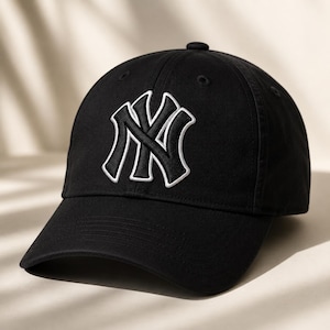 以下が含まれることがあります： 白の縁取りが施された白い「NY」ロゴが特徴の黒い野球帽。 つばがカーブしており、後ろに調節可能なストラップが付いています。 カジュアルウェアやスポーツに最適な、クラシックなデザインの帽子です。