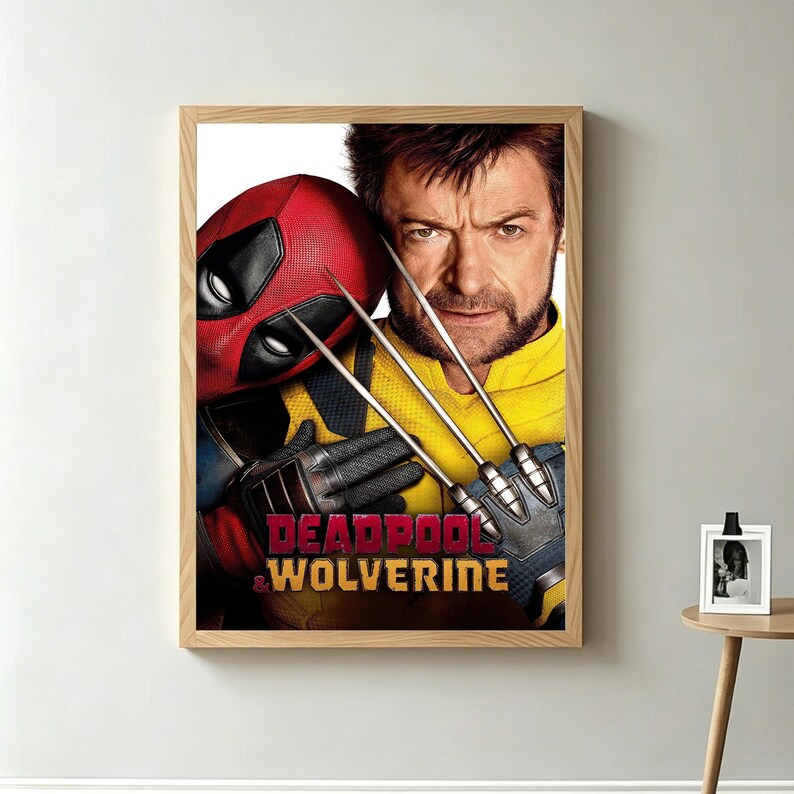 May include: A framed poster featuring Deadpool and Wolverine. Deadpool is wearing his red mask, and Wolverine is in a yellow and black suit, holding his claws. The poster has the words "Deadpool & Wolverine" at the bottom.