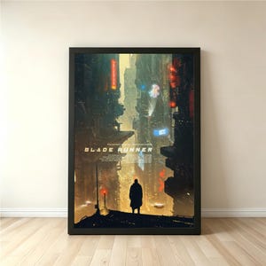 May include: A framed vertical poster featuring a dark, futuristic cityscape with towering buildings, glowing neon signs, and a lone silhouette standing in the foreground. The text BLADE RUNNER is printed in white in the centre of the artwork.
