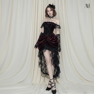 May include: A burgundy velvet off-the-shoulder dress with black lace trim and accents. The dress features a corset-style bodice and a high-low hemline. Black lace gloves and a choker complete the gothic-inspired ensemble.