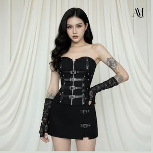 以下が含まれることがあります： シルバーのリベットとバックルが付いた黒のストラップレスコルセットトップと、お揃いの黒のミニスカート。 トップはジッパー開閉と革のアクセントが特徴です。 この衣装は、黒のレースのフィンガーレスグローブで完成しています。