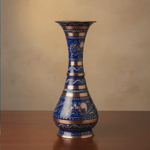 Könnte beinhalten: Eine hohe, verzierte Vase in tiefblau mit kupferfarbenen Bändern und floralen Mustern. Die Vase hat einen ausgestellten oberen Rand, einen schlanken Hals und einen bauchigen Boden. Das Design ist symmetrisch, etwa 30 cm hoch.