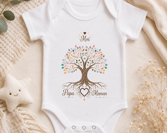 May include: A white short-sleeved baby bodysuit featuring a central graphic of a tree with colorful leaves and exposed roots. The text "Moi" appears above the tree, while "Papa" and "Maman" are printed on either side of a heart at the base.