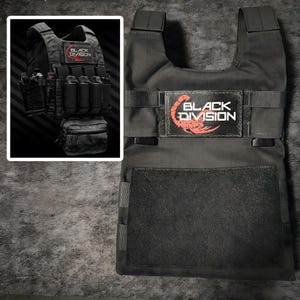 Può includere: Un gilet tattico nero con una toppa rettangolare recante la scritta BLACK DIVISION e un grafico di uno scorpione rosso. Il gilet presenta ampi spallacci, fettucce orizzontali e un ampio pannello in velcro sulla parte anteriore del petto.