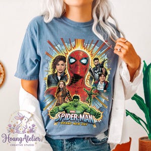 May include: Blue t-shirt featuring a graphic of Spider-Man and other Marvel characters. The design includes the text "SPIDER-MAN BRAND NEW DAY". The shirt is a light blue color.