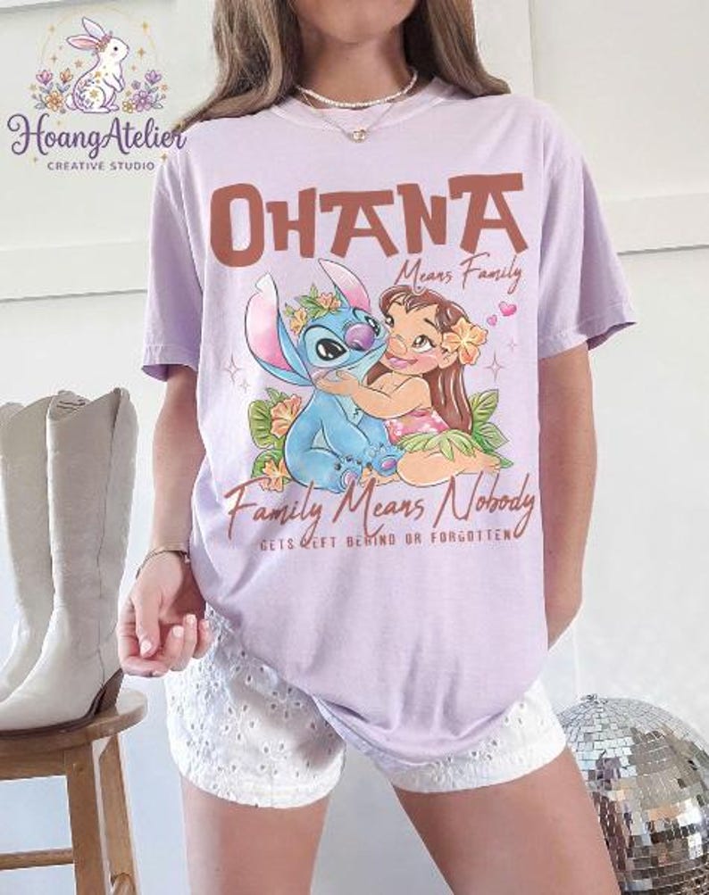 Op de afbeelding: Lichtpaars T-shirt met de tekst "OHANA Means Family" en een afbeelding van Stitch en Lilo. Het shirt bevat ook de tekst "Family Means Nobody Gets Left Behind or Forgotten."