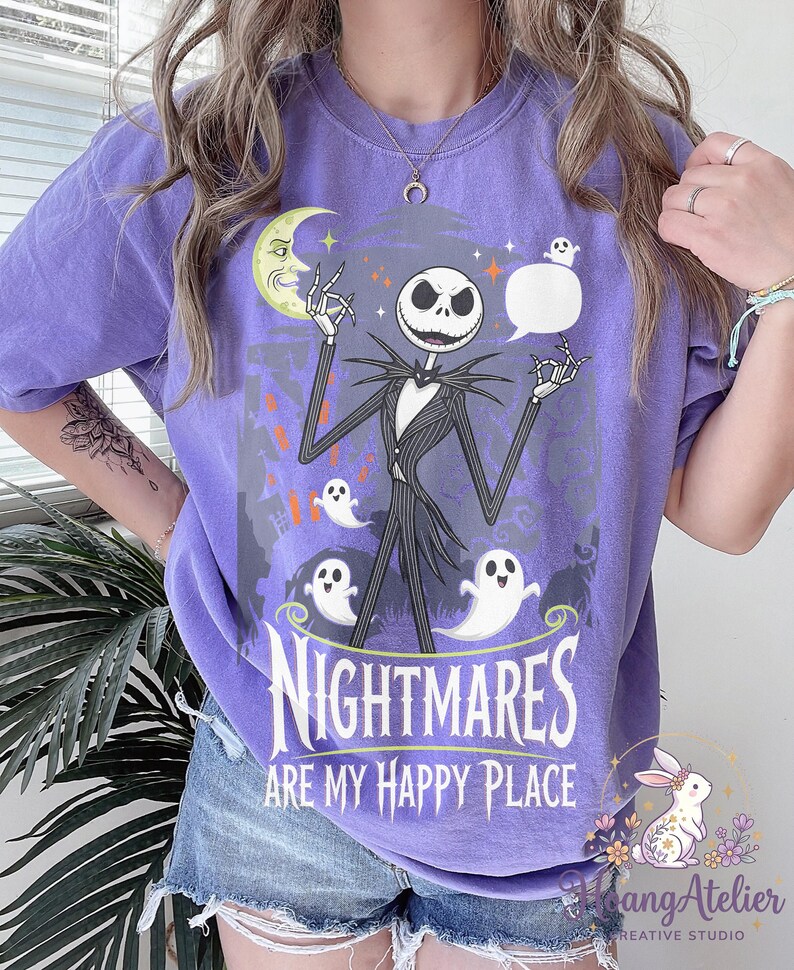 May include: A lilac t-shirt with a graphic of Jack Skellington. The design includes a moon, ghosts, and the text "Nightmares are my happy place."