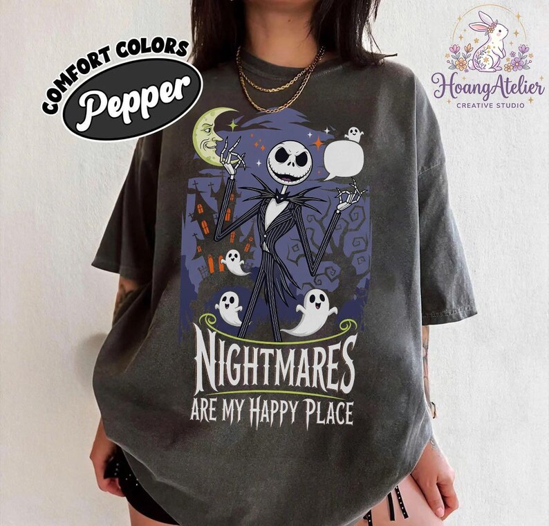 May include: Dark grey t-shirt with a graphic of Jack Skellington, ghosts, and the text "NIGHTMARES ARE MY HAPPY PLACE." The shirt has a distressed look and the word "Pepper" is printed on the top left. The design is from The Nightmare Before Christmas.