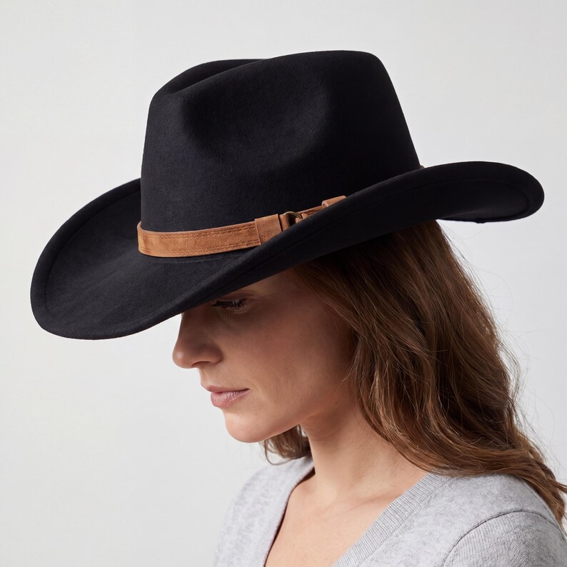 May include: A black cowboy hat with a brown leather band. The hat has a wide brim and a classic western design. The hat is made of a felt-like material.