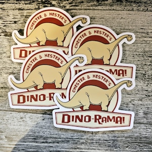 Op de afbeelding: Vier stickers met een cartoon dinosaurus met de tekst "Chester & Hester's Dino-Rama!" in een retro stijl.