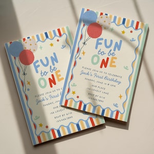 Op de afbeelding: Twee rechthoekige verjaardagsuitnodigingskaarten met een kleurrijke gestreepte rand en een geschulpte binnenrand. De tekst luidt FUN to be ONE, Jack's First Birthday, Sunday, June 14 at 2PM, Our Place, 126 Lovely Lane, RSVP by 6/10, 123.456.7890.