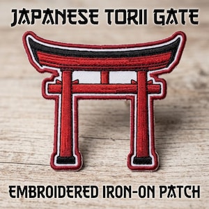 May include: An embroidered iron-on patch featuring a Japanese torii gate design in red, black, and white thread. The patch displays the text JAPANESE TORII GATE at the top and EMBROIDERED IRON-ON PATCH at the bottom in black lettering.