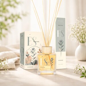 Könnte beinhalten: Ein klarer Glas-Diffusor für ätherische Öle mit Holzstäbchen und einem Holzdeckel. Der Diffusor ist mit einer gelben Flüssigkeit gefüllt und wird mit einer passenden Schachtel und Verpackung geliefert. Auf der Schachtel und der Flasche steht "ES Essenze" und florale Illustrationen.