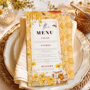 Könnte beinhalten: Eine rechteckige Menükarte mit Honig- und Bienenmotiv, Wabenmuster, herabtropfendem Honig und gelben Wildblumen. Der Text lautet "the MENU", gefolgt von Abschnitten für SALAD, ENTREE und DESSERT mit detaillierten Speisebeschreibungen.