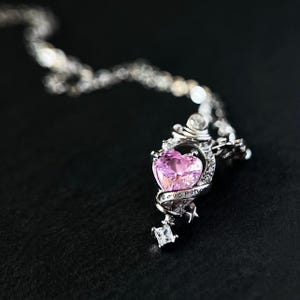 May include: A white ceramic mug with a black handle and the text "But First, Coffee" in a bold, black font. The mug is set against a blurred background, suggesting a cozy setting.