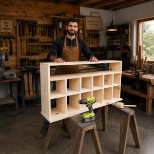 Peut inclure: Une étagère à casiers en bois clair dotée de dix compartiments de rangement rectangulaires disposés sur deux rangées. L'étagère est fabriquée à partir de planches de pin brut et est posée sur un établi en bois à côté d'une perceuse vert lime.