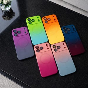May include: A selection of vibrant phone cases with a gradient effect. The cases display a spectrum of colours, such as green, orange, yellow, blue, pink, and purple. Each case has a circular design and a camera aperture.